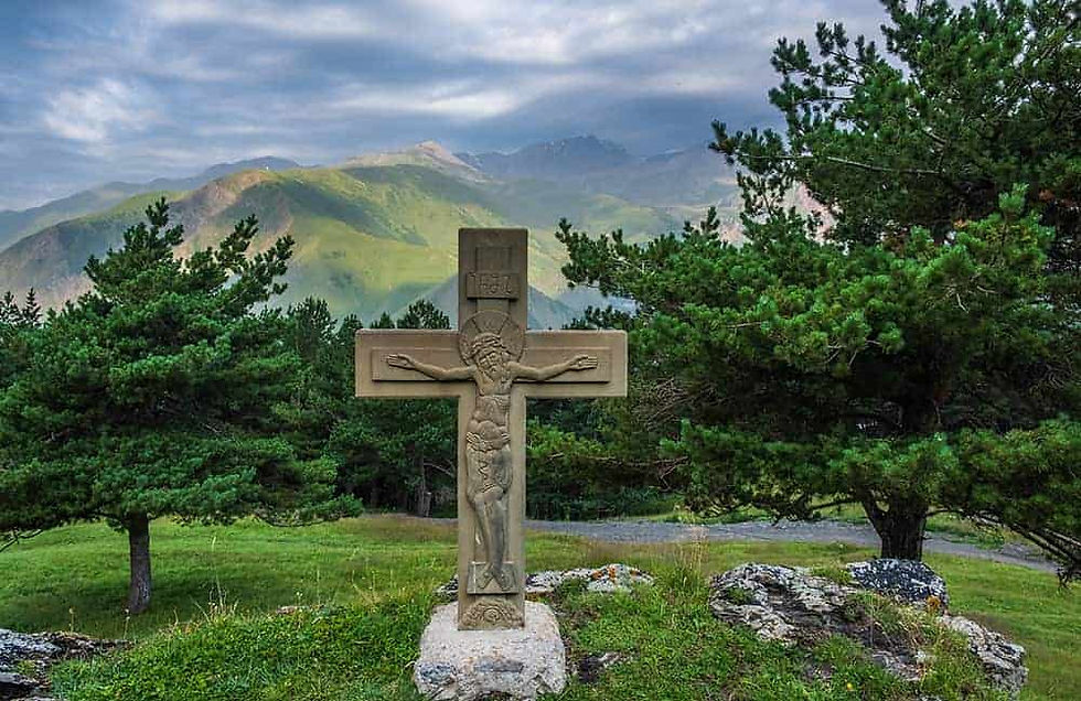 Crucifix among trees and hills
