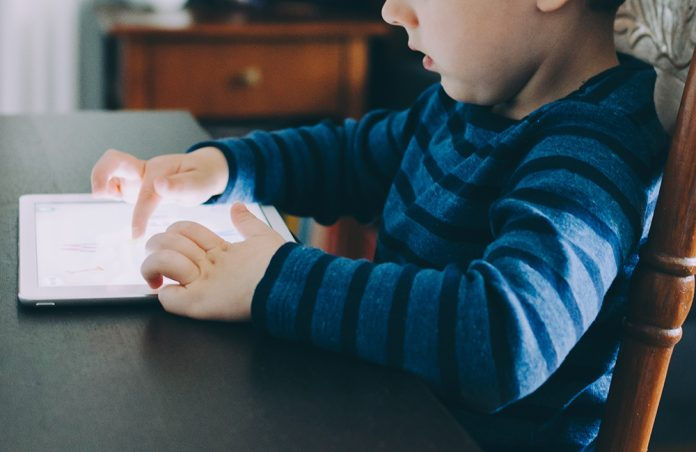 Kid playing on an iPad