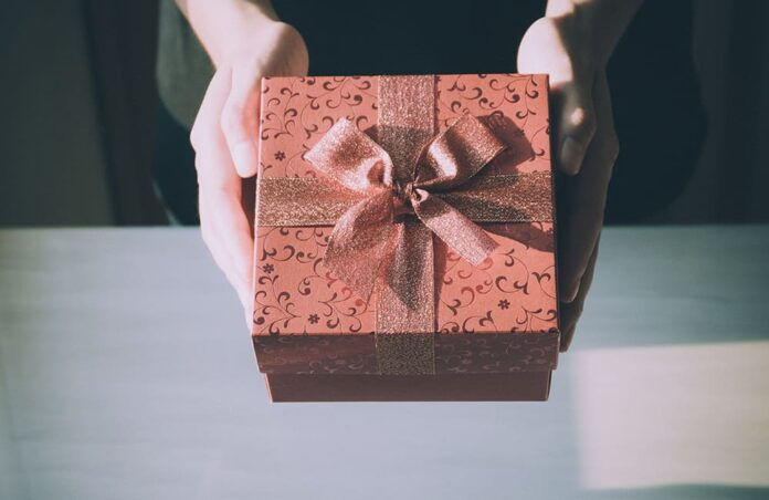 Close up of woman hands holding red gift box for special event (Photo: Pexels)