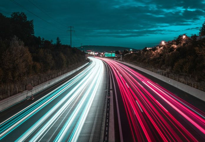 Highway at night with blur of lights from cars driving by