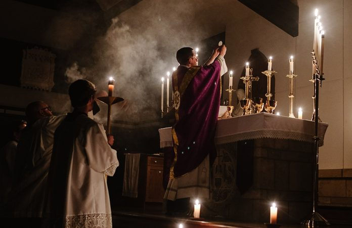 Priest elevating the Eucharist during the Mass