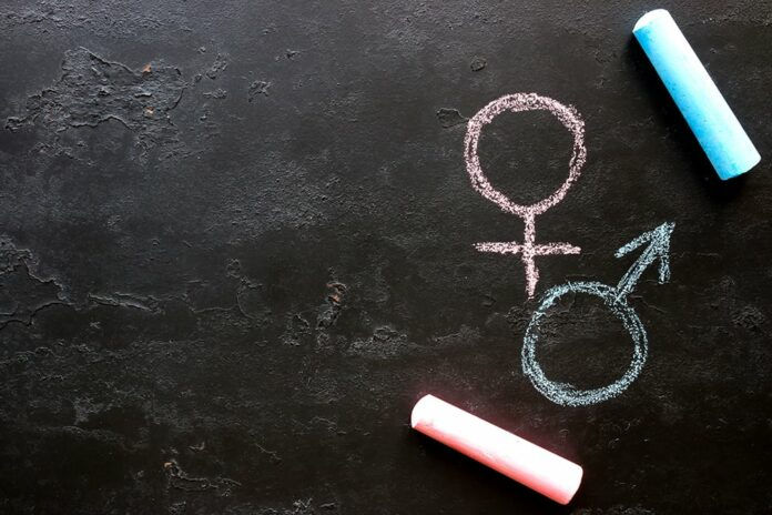 Male and female gender symbols on a black background with space for text (Photo: Adobe Stock)